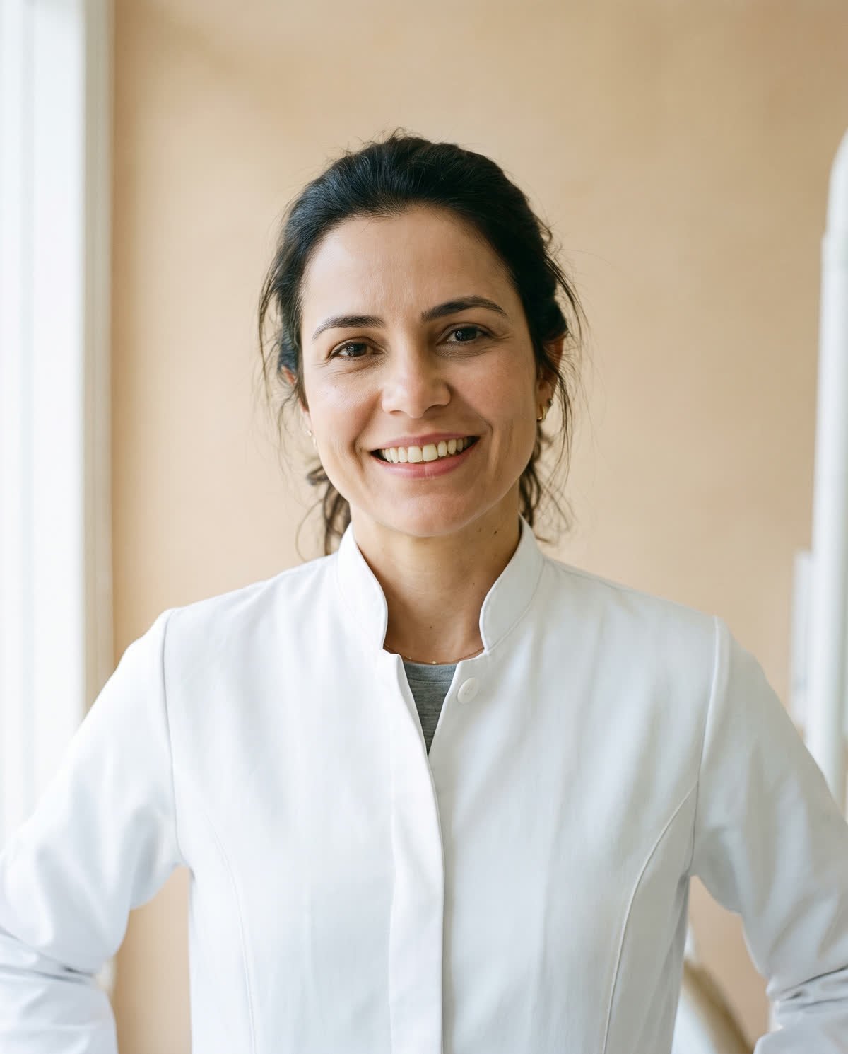 Dra. Carolina Bianchi, de jaleco branco, na clínica
